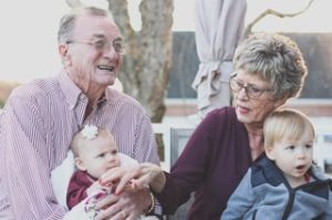 A grandmother and grandfather holding their grandchildren